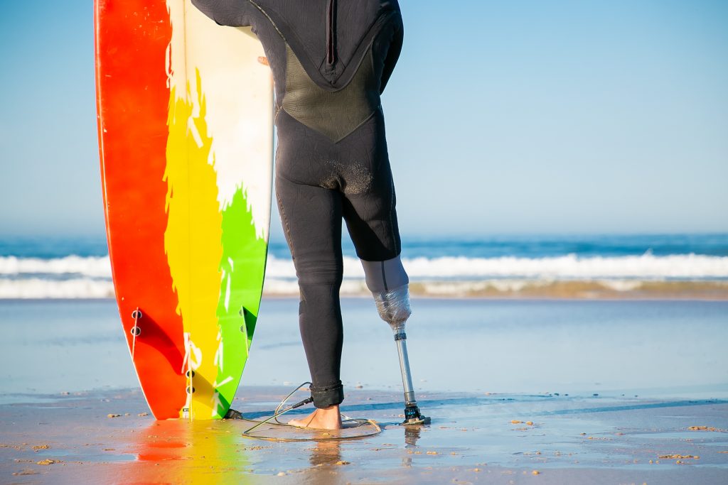 Vue d'un surfeur avec un handicap de la jambe.