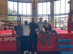 Personnes assisent sur un ring de boxe.